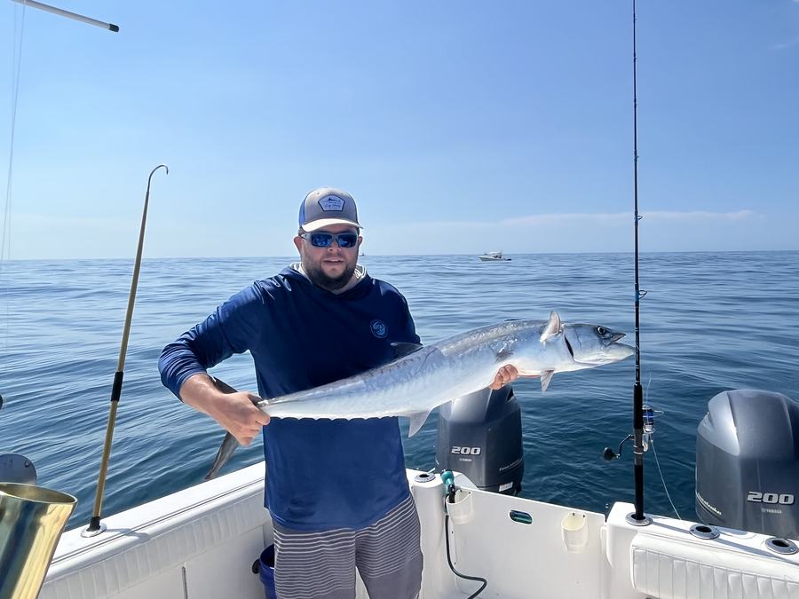 Mark Gabrielli holding a large fish on a boat offshore